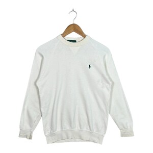 May include: White long-sleeve sweatshirt with a crew neck and raglan sleeves. A small green logo of a person on a horse is embroidered on the chest. The sweatshirt is hanging on a wooden hanger.