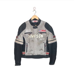 May include: A grey and black motorcycle jacket with the words "SIMPSON Racing" printed on the front. The jacket has red and white accents and multiple pockets.