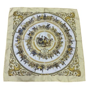 May include: A square silk scarf in cream with a white center featuring a detailed illustration of horse-drawn carriages. The design includes the text La Promenade de Longchamps and Hermes Paris, surrounded by ornate gold horse head motifs.