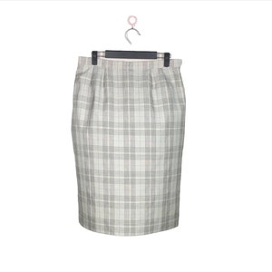 May include: A white skirt with a black and gray plaid pattern. The skirt is knee-length and has a straight silhouette.