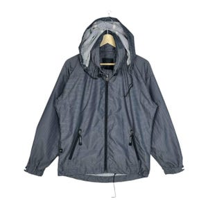 May include: A dark gray hooded jacket featuring a subtle grid pattern, a full-length black front zipper, and two zippered side pockets. The jacket includes a light gray interior lining, adjustable drawstrings at the hood, and long sleeves.