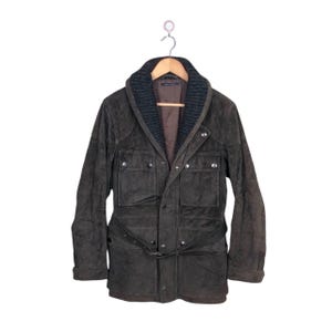 May include: A brown suede jacket with a black knit collar, a button closure, and a belt at the waist.