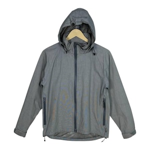 May include: A grey hooded jacket with a full-length zip, two side pockets, and a drawstring at the hem. The jacket features a hood and long sleeves. The jacket is made of a lightweight material.