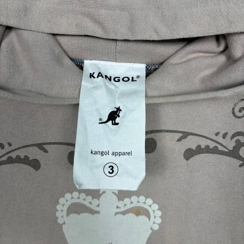 May include: A set of three ceramic mugs with a speckled, matte finish. The mugs are in shades of cream, light brown, and dark brown. Each mug has a simple, minimalist design, suitable for coffee or tea.