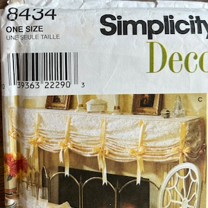 May include: Simplicity pattern number 8434 for a fireplace valance. The pattern is for one size and includes instructions for making a white valance with yellow ribbon bows. The pattern is labelled "Decor" and has a barcode.