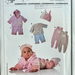 Peut inclure: Un patron de couture pour une tenue de bébé. Le patron comprend une veste à capuche rose, un pantalon rose, une veste rayée bleu et jaune, un pantalon bleu, une combinaison rayée rose et jaune et un bonnet rayé rose et blanc. Le patron est de Burda et porte le numéro 9636. Le texte sur le patron dit "leicht, facile, easy, fácil." et "KOMBINATION COORDONNES COORDINATES COORDINADOS".