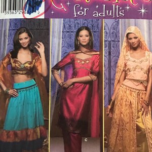 May include: A Simplicity sewing pattern for adult costumes. The pattern is for three different costumes: a turquoise skirt with a gold top, a red trouser suit with a gold top, and a gold skirt with a gold top. The pattern number is 4249 and the sizes are 6, 8, 10, and 12.