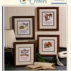 Peut inclure: Un livre de modèles de point de croix chrétiens avec des illustrations d'animaux adorables. La couverture du livre montre quatre modèles de point de croix encadrés avec des versets de la Bible. Les motifs comprennent une tortue, un singe, un ours et un lapin.