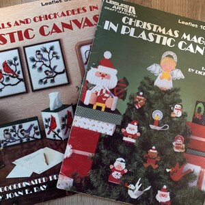 Peut inclure: Deux brochures d'artisanat vintage : "Cardinals and Chickadees in Plastic Canvas" et "Christmas Magic in Plastic Canvas". La brochure de Noël présente un sapin de Noël orné. L'autre brochure montre des motifs d'oiseaux.