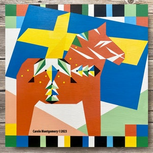 May include: A colourful abstract painting of a red and white Dala horse with a yellow cross on a blue background. The painting is framed with a black and white border.