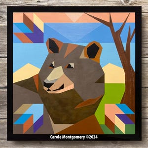 May include: Geometric style painting of a brown bear with a blue, green, and yellow background. The bear is looking to the left of the image. The painting is framed in black and has the artist's signature and copyright date in the bottom right corner. "Carole Montgomery ©2024"