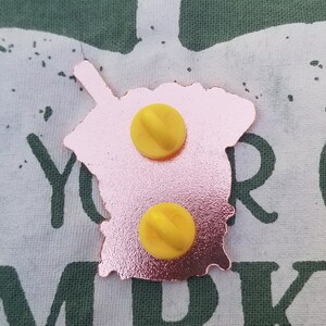 Pode incluir: Pin de esmalte dourado rosa com uma imagem de desenho animado rosa e branca de um copo de boba tea com um canudo. O pin tem dois fechos de metal amarelos na parte de tr&aacute;s.