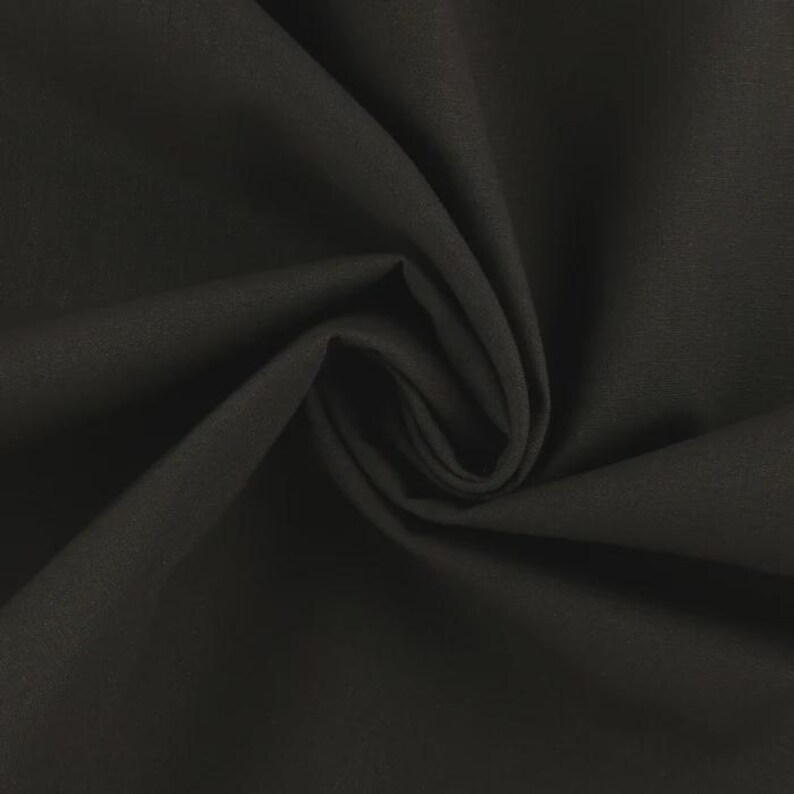 Op de afbeelding: Close-up van een donkergrijze stof met zachte plooien en een subtiele textuur. Het materiaal is effen van kleur, zonder zichtbare patronen of ontwerpen. De stof is strak geweven en heeft een matte afwerking.