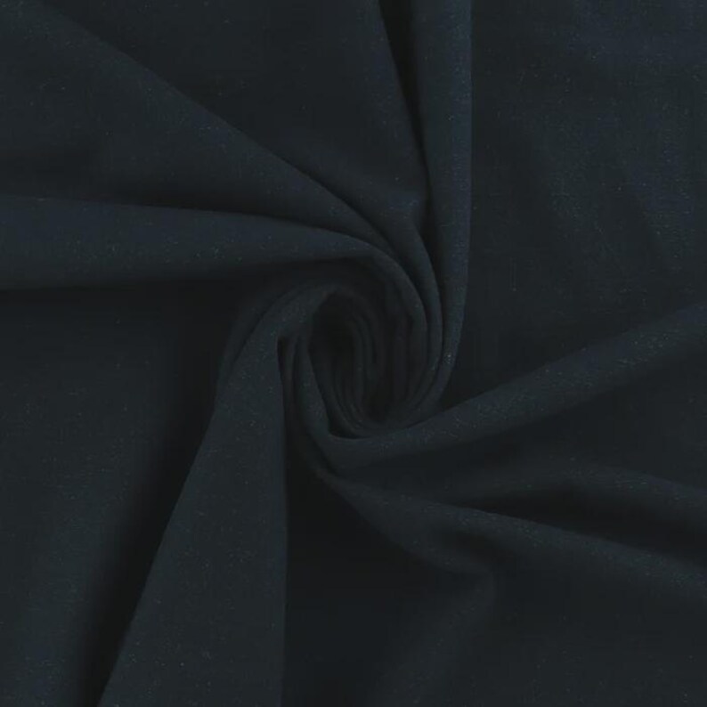 Op de afbeelding: Een close-up van een donker marineblauwe stof, met zachte plooien en een subtiele textuur. De stof is in een spiraalvorm verzameld, waardoor schaduwen ontstaan en de drapering en glans van het materiaal worden benadrukt. De algehele uitstraling is glad en luxueus.