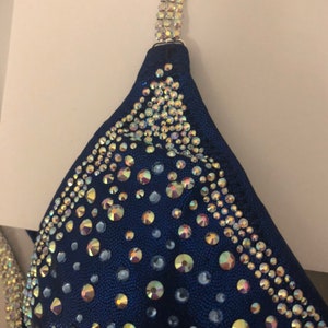 May include: A navy blue bikini top with iridescent rhinestones in a geometric pattern.