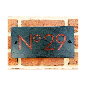 May include: A black slate house number sign with red lettering that reads "No. 29".