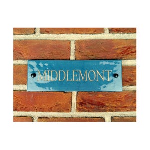 以下が含まれることがあります： レンガの壁に、金色の文字で「MIDDLEMONT」と書かれた青いスレート製の家の番号札