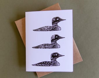 Pode incluir: Um cartão branco com três ilustrações em preto e branco de pássaros mergulhadores. Cada pássaro é estilizado com padrões e detalhes intrincados.