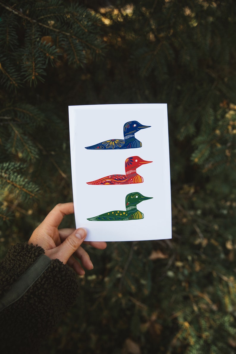 May include: A white card with three colorful loon illustrations. The loons are in a row, with the top loon blue, the middle loon red, and the bottom loon green. Each loon has a detailed pattern.