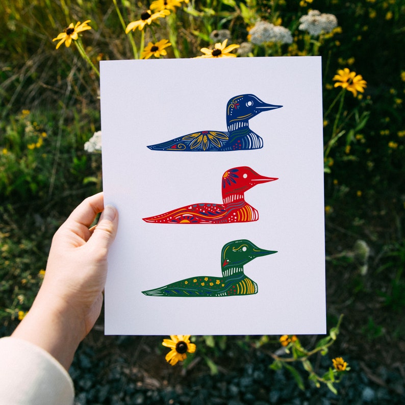 May include: A white card with three colorful loon illustrations. The loon on the top is blue with white and yellow accents. The middle loon is red with white and yellow accents. The bottom loon is green with white and yellow accents.