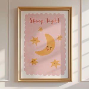 May include: A framed print with a gold border featuring a pink background with a scalloped edge. The print displays a yellow crescent moon with a smiling face and several yellow stars. The text "Sleep tight" is written in pink.