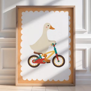 Pode incluir: Uma impressão de arte emoldurada apresentando um ganso branco com bico e patas laranja andando em uma bicicleta amarela com detalhes vermelhos e azuis. A ilustração está sobre um fundo branco com borda recortada dentro de uma moldura laranja.