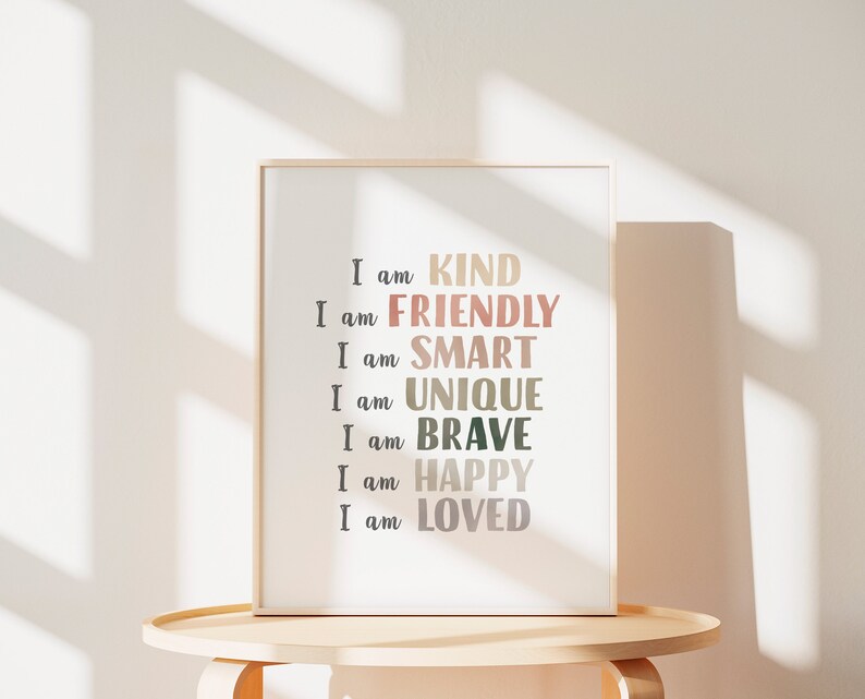 May include: A framed print with the text "I am KIND, I am FRIENDLY, I am SMART, I am UNIQUE, I am BRAVE, I am HAPPY, I am LOVED" in a variety of colors on a white background.