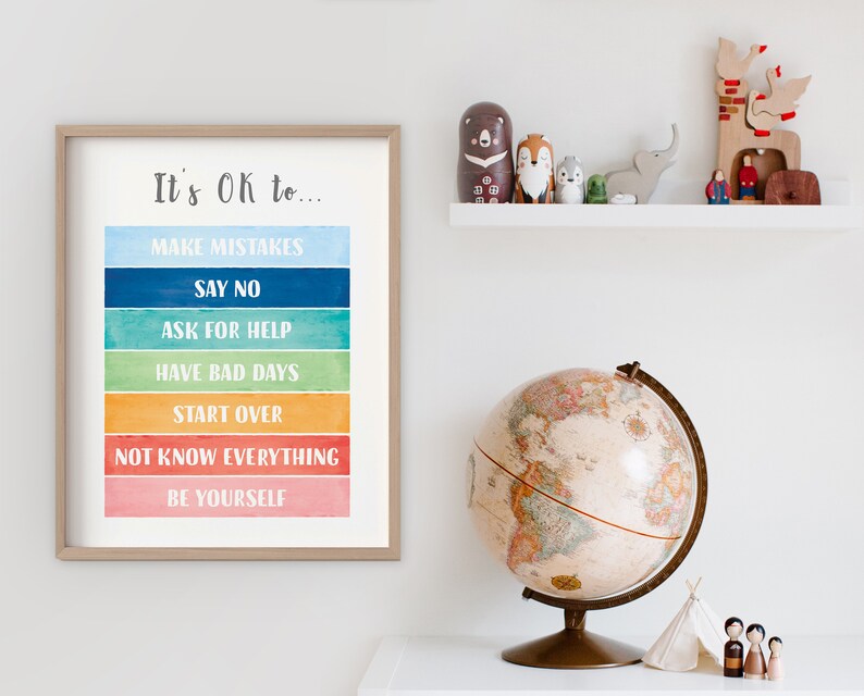 Op de afbeelding: Een ingelijst afdruk met een aquarel achtergrond en de tekst "It's OK to..." gevolgd door een lijst met zinnen: "Make Mistakes", "Say No", "Ask for Help", "Have Bad Days", "Start Over", "Not Know Everything", en "Be Yourself".