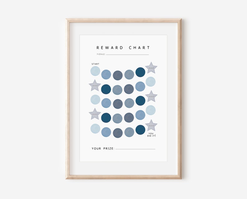 May include: A blue and white reward chart with a grid of circles and stars. The chart has the text "REWARD CHART" at the top and "YOU DID IT!" at the bottom. The chart is framed in a light wood frame.