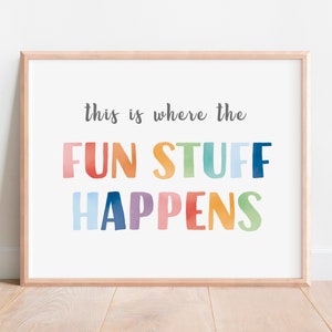 May include: A framed print with the text "This is where the fun stuff happens" in rainbow colors. The text is in a playful, hand-drawn style.