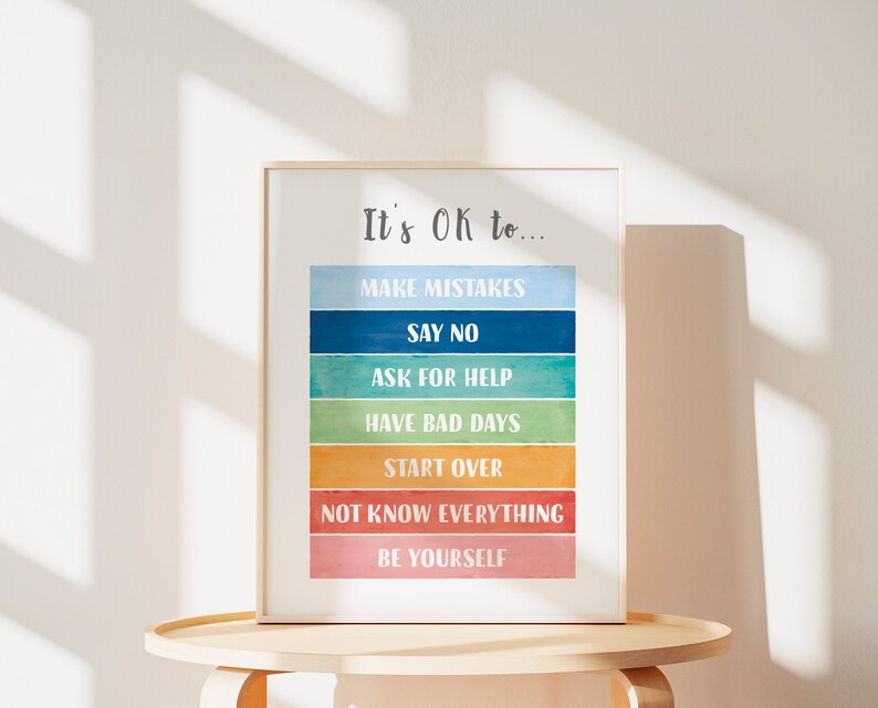 Op de afbeelding: Een ingelijst print met een kleurrijk aquarelontwerp en de tekst "It's OK to..." gevolgd door een lijst met positieve affirmaties: "Make Mistakes", "Say No", "Ask for Help", "Have Bad Days", "Start Over", "Not Know Everything", en "Be Yourself".
