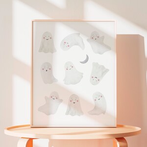 Puede incluir: Una impresi&oacute;n enmarcada con fondo blanco y un patr&oacute;n de 10 lindos fantasmas de dibujos animados con diferentes expresiones. Los fantasmas est&aacute;n en varias poses, algunos est&aacute;n volando, algunos est&aacute;n durmiendo y algunos est&aacute;n sonriendo. Hay una luna creciente en la parte superior central de la impresi&oacute;n.