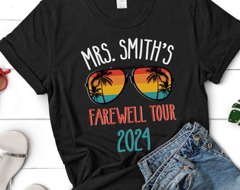 May include: Black t-shirt with the text "MRS. SMITH'S FAREWELL TOUR 2024" in white and teal. The text is surrounded by a graphic of retro sunglasses with palm trees reflected in the lenses.