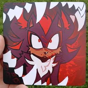 May include: A square print featuring a stylized illustration of a dark purple and red hedgehog character with sharp white teeth, red eyes, and red markings. The character is surrounded by jagged white shapes against a deep red background.