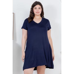 Puede incluir: Vestido azul marino de manga corta con cuello en V. El vestido tiene un dobladillo asim&eacute;trico y fluido. La modelo lleva el vestido en un estudio con fondo blanco.