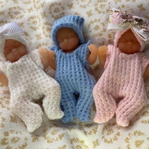 Schlafmützen und Mützen in weiß, rosa und blau gestrickt