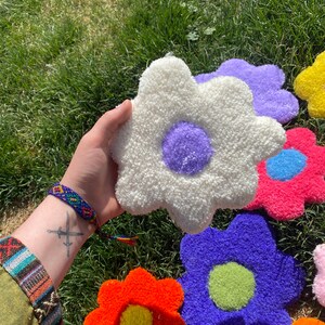 May include: A collection of colorful, fluffy, daisy-shaped rugs with different colored centers. The rugs are made of a soft, fuzzy material and are perfect for adding a touch of whimsy to any room.