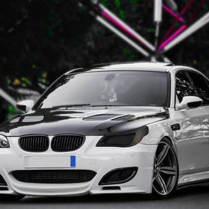 Może przedstawiać: Biały sedan BMW z czarnymi akcentami i przyciemnianymi szybami. Samochód ma czarną kratkę i czarne reflektory. Samochód jest zaparkowany na utwardzonej powierzchni.