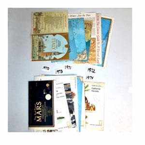 May include: A collection of vintage travel guides and maps from the 1970s, including guides to Italy, Mars, and California and Nevada. The guides are arranged in chronological order, with the earliest guide from 1970 and the latest from 1974.