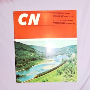 May include: A red and white cover of a Canadian National Railways system time table from October 30, 1960 to April 29, 1961. The cover features a large CN logo and a scenic image of a train traveling through a valley with a river.