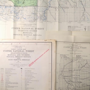 May include: A collection of vintage maps of the Custer National Forest, including the Beartooth Division in Montana and Wyoming. The maps feature detailed geographical information, including rivers, roads, and forest boundaries. The maps are from 1938.