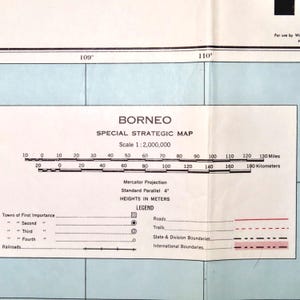 May include: A detailed map of Borneo, labeled "Special Strategic Map." The map includes a scale of 1:2,000,000, with measurements in miles and kilometers. Features include roads, trails, and international boundaries. The map is printed on aged paper.