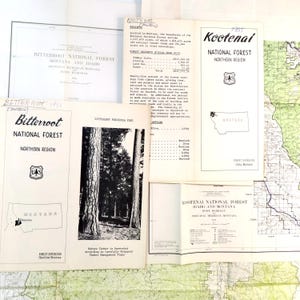 May include: A collection of vintage documents and maps related to the Bitterroot and Kootenai National Forests in Montana and Idaho. Includes brochures, receipts, and a map, all in black and white.