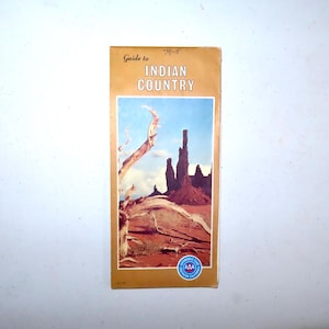 May include: A vintage travel guide titled "Guide to Indian Country" with a landscape photo of rock formations and a blue sky. The cover is tan with the AAA logo.