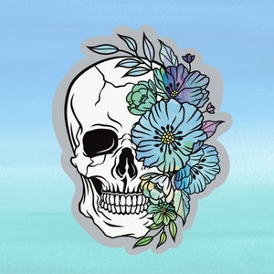 May include: A white skull with a floral design covering one eye. The flowers are blue, purple, and green.