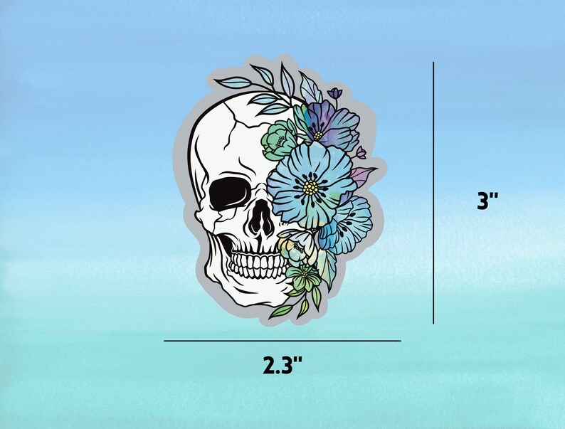 May include: A white skull with a floral design in shades of blue, green, and purple. The skull is 2.3 inches wide and 3 inches tall.