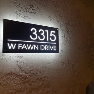Pu&ograve; includere: Un cartello di numero civico illuminato in bianco e nero con l'indirizzo 3315 W FAWN DRIVE.