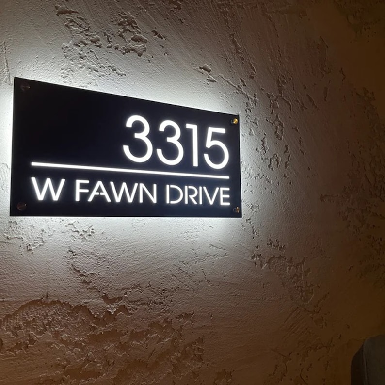 Pu&ograve; includere: Un cartello di numero civico illuminato in bianco e nero con l'indirizzo 3315 W FAWN DRIVE.