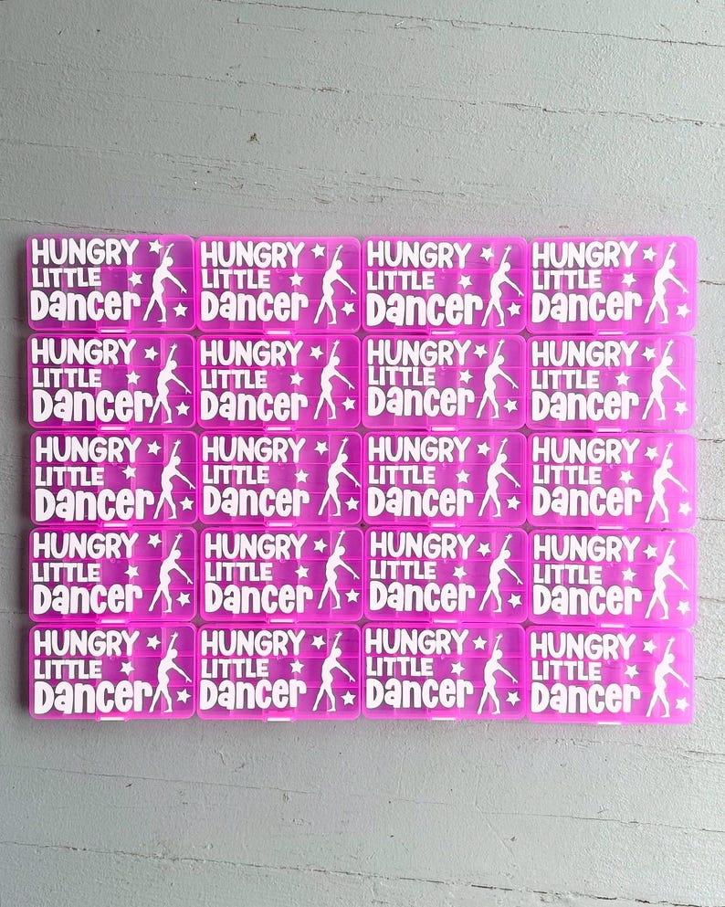 May include: A grid of pink rectangular stickers, each bearing the white text "HUNGRY LITTLE DANCER". The design includes a dancer silhouette and stars. The stickers are suitable for various craft projects.