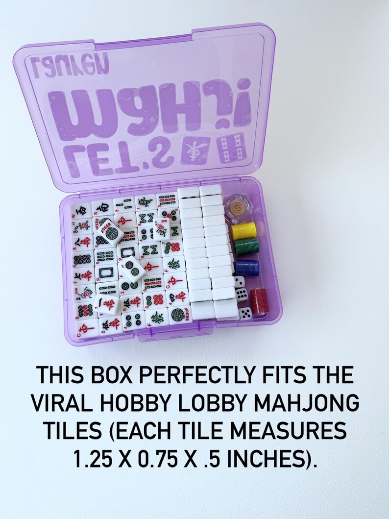 May include: A purple plastic box containing a Mahjong set. The box is open, revealing white tiles with red, green, and black symbols. Dice and colored chips are also visible. The text on the box reads "TSOLGN WgH?i &Gamma;&Epsilon;1.2".